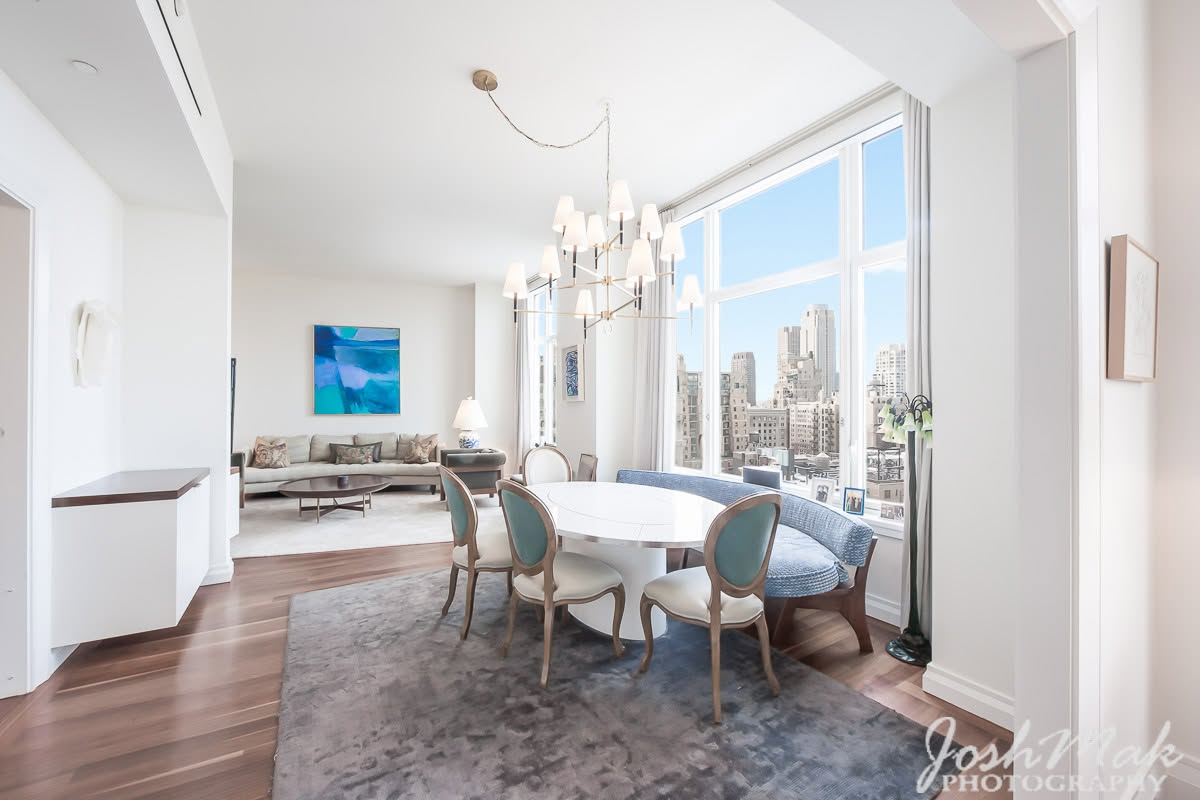 Bright dining room with chandelier and Midtown Manhattan skyline views, Upper East Side apartment by Josh Mak Photography